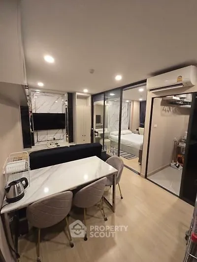 Modern apartment interior with open layout dining and living area, featuring sleek furniture and ambient lighting.