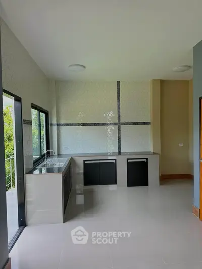 Modern kitchen with sleek design and large windows offering natural light