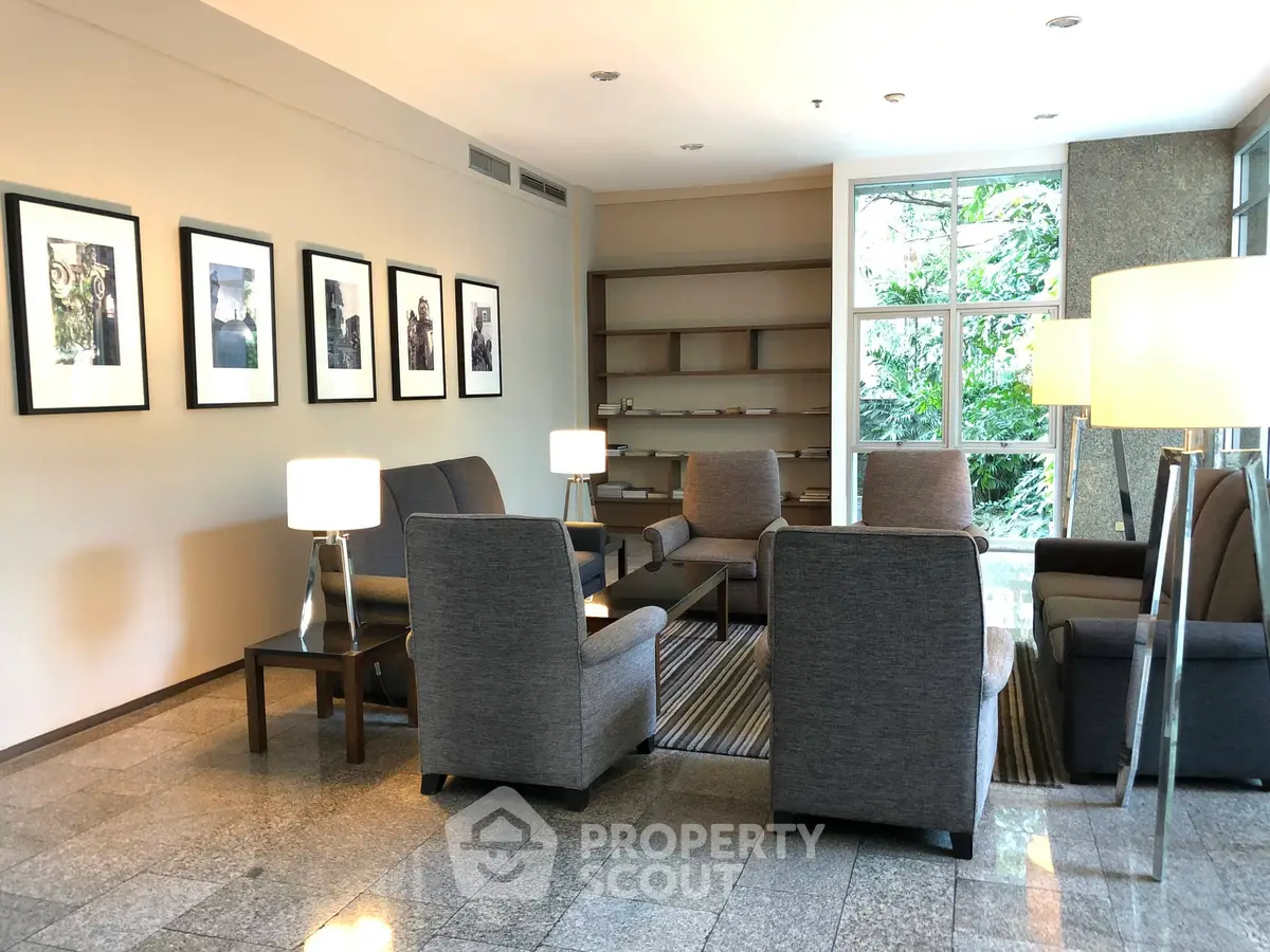 Elegant lobby with modern seating and large windows offering lush garden views.
