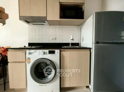Modern kitchen with washing machine and fridge in compact layout