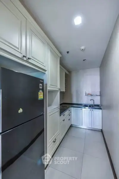 Modern kitchen with sleek cabinetry and stainless steel appliances in a compact layout.