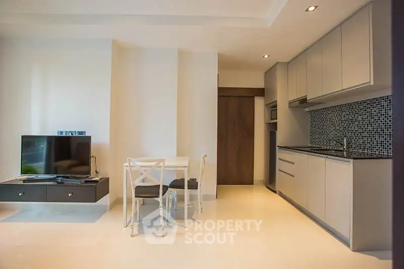 Modern open-plan kitchen and living area with sleek design and stylish furnishings.