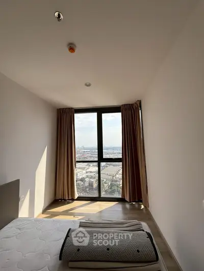 Bright bedroom with large window offering stunning city view