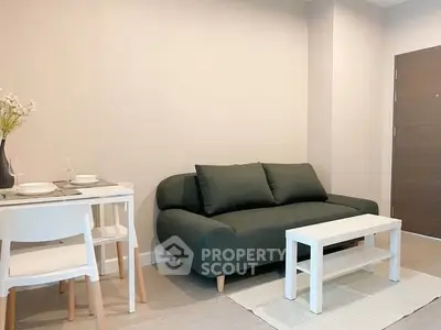 Modern living room with sleek sofa and dining area in minimalist apartment.