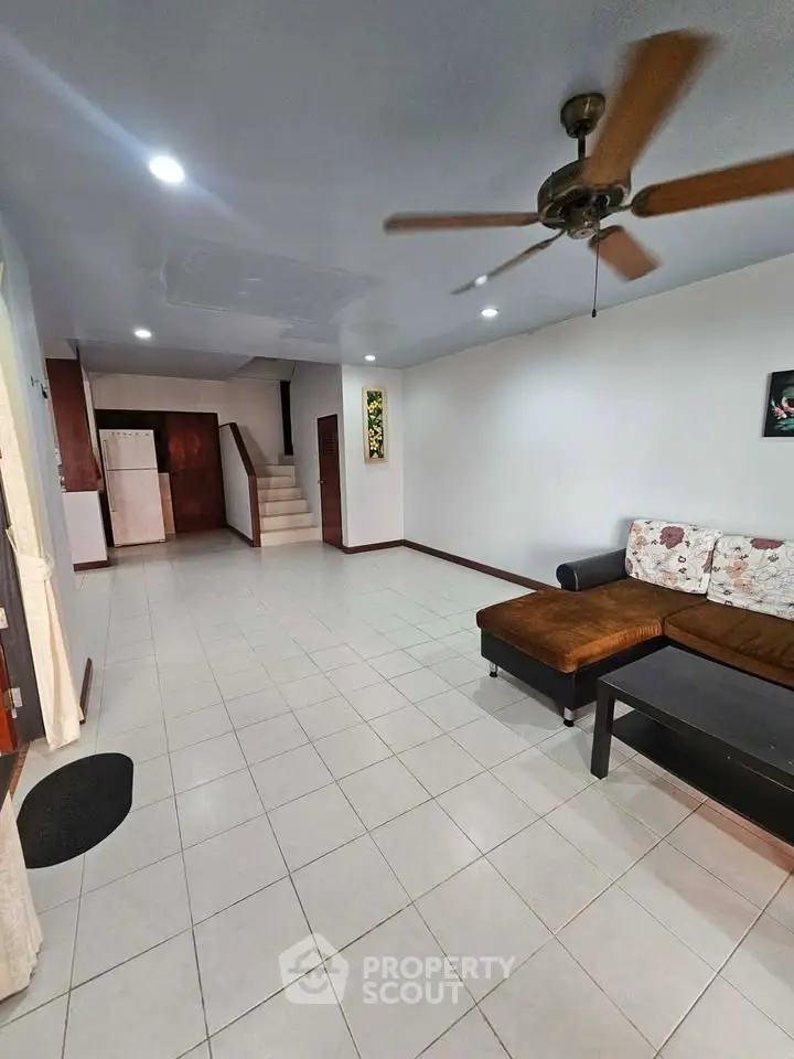 Spacious living room with ceiling fan and modern decor in a stylish home.