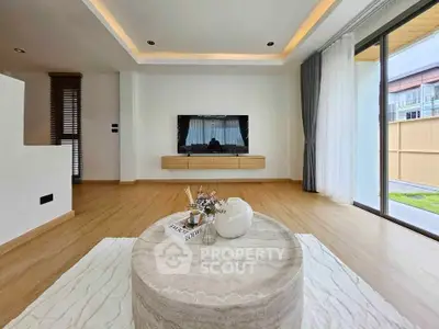 Modern living room with stylish decor and large windows offering natural light.