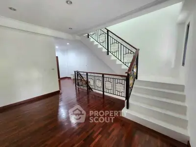 Spacious interior with elegant wooden flooring and stylish staircase in modern home