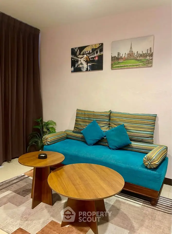 Cozy living room with vibrant sofa and modern wooden tables, perfect for relaxation and entertaining.