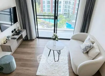 Modern living room with pool view, stylish furniture, and large windows in a luxury apartment.