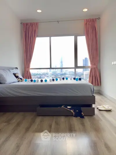 Spacious bedroom with large window offering stunning city views and elegant decor.