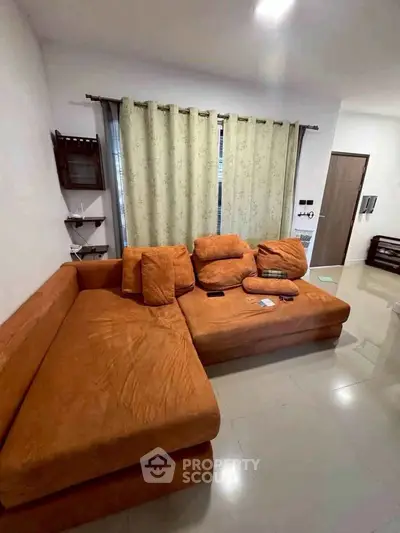 Cozy living room with orange sectional sofa and modern decor