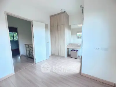 Spacious bedroom with modern wooden flooring and built-in wardrobe, perfect for a cozy living space.