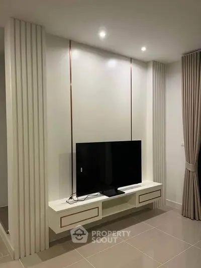 Modern living room with sleek TV setup and elegant curtains