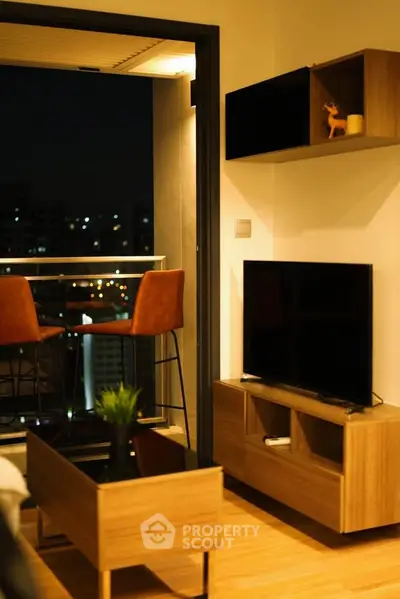 Modern living room with balcony view, stylish furniture, and warm lighting