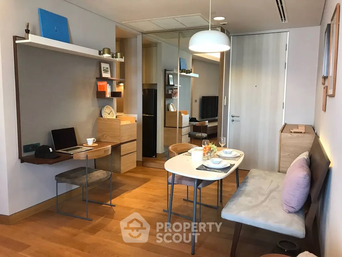 Modern living room with dining area and workspace, featuring stylish decor and wooden flooring.