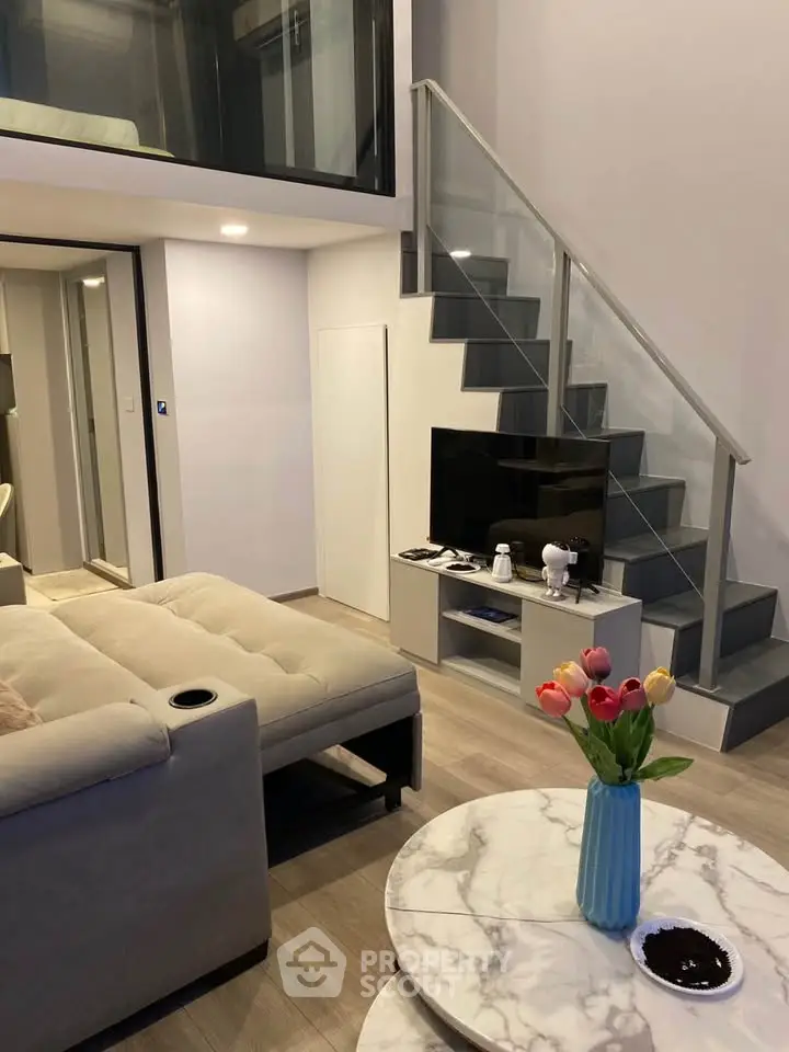 Modern living room with loft, stylish staircase, and cozy seating area in contemporary apartment.