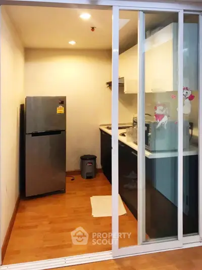 Modern kitchen with closed layout and sleek appliances in compact space.