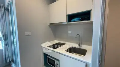 Compact modern kitchen with sleek cabinetry and built-in appliances in a stylish apartment.