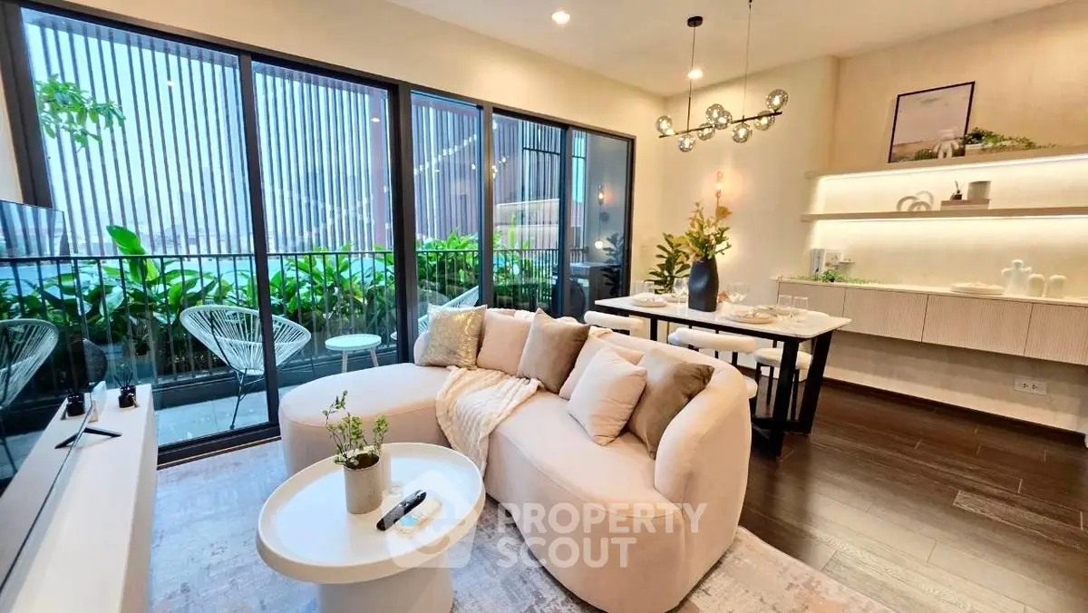 Luxurious modern living room with elegant decor and large windows opening to a lush balcony view.