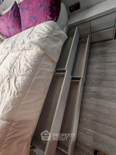 Modern bedroom with stylish storage drawers under bed and elegant decor.