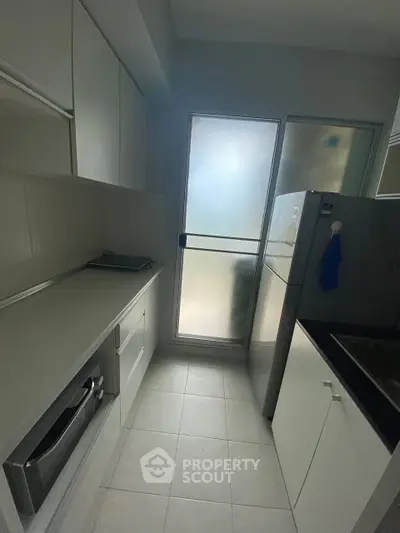 Modern compact kitchen with sleek cabinetry and stainless steel appliances