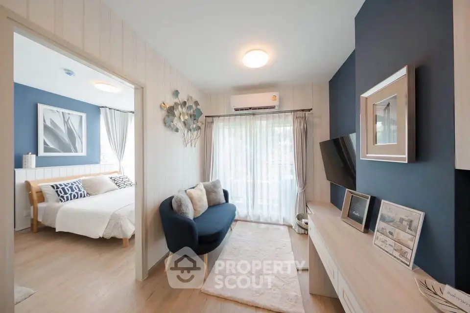 Modern living room with stylish decor and view into cozy bedroom