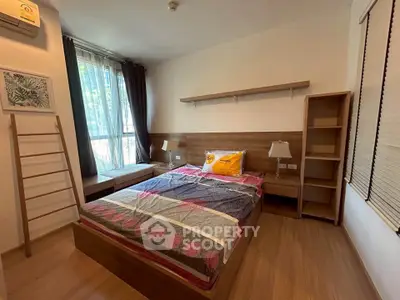 Cozy bedroom with wooden flooring, large window, and modern furnishings for a serene living experience.