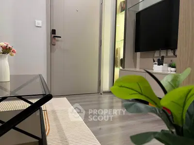 Modern living room with sleek decor and stylish furniture, featuring a TV and elegant flooring.