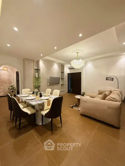 Luxurious open-plan living and dining area with elegant decor and modern lighting.