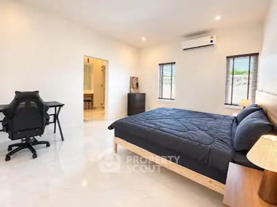Spacious modern bedroom with sleek furnishings and natural light