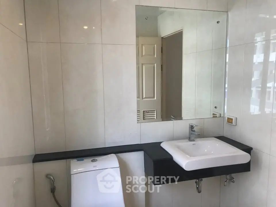 Modern bathroom with sleek fixtures and large mirror