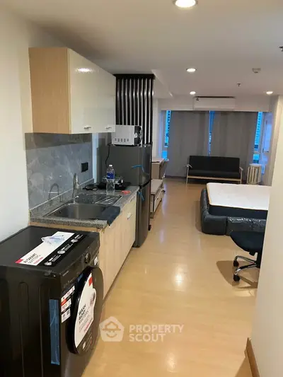 Modern studio apartment with open kitchen layout and stylish furnishings.