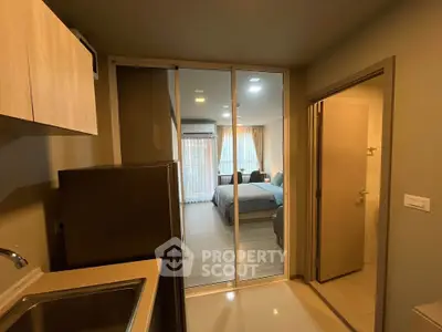 Modern studio apartment with open layout, featuring a cozy bedroom and compact kitchen area.