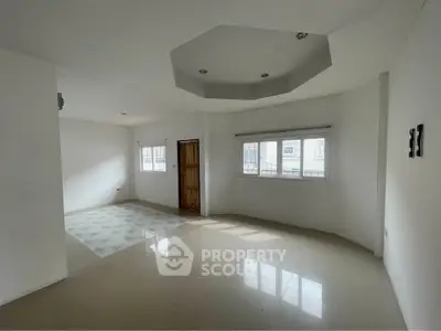 Spacious living room with modern ceiling design and large windows for natural light.
