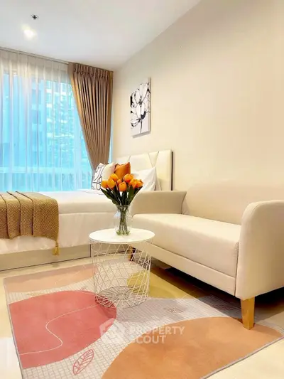 Chic modern living room with cozy sofa, stylish rug, and bright window view.