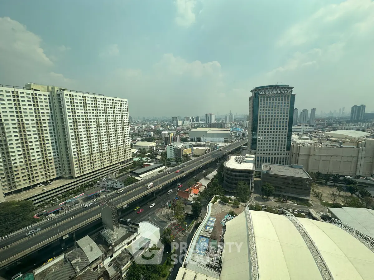 Stunning cityscape view from high-rise building with expansive skyline and bustling roads.