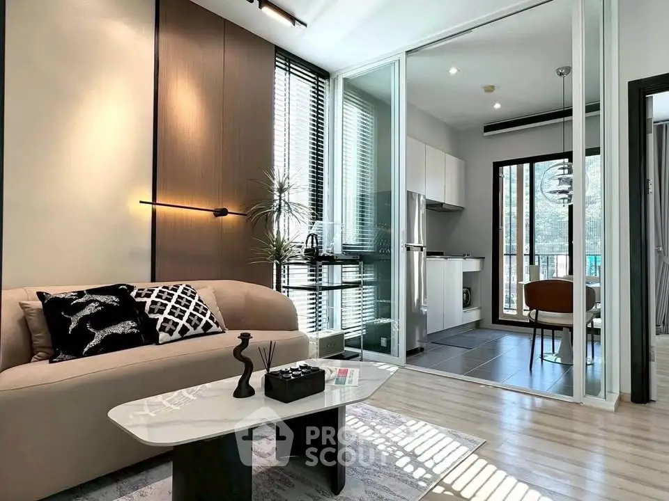 Modern living room with stylish decor and open kitchen layout, featuring floor-to-ceiling windows and elegant furnishings.