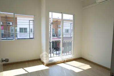 Bright empty room with large windows and wooden flooring in modern apartment