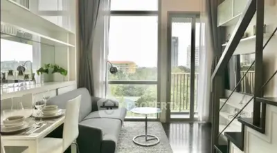 Modern living room with large windows and balcony view in a stylish apartment.