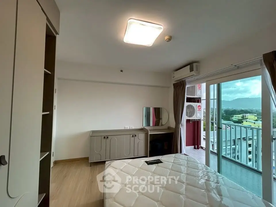 Spacious bedroom with balcony offering stunning mountain views in modern apartment.