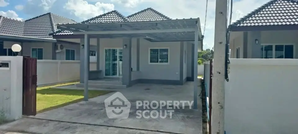 Modern single-story house with spacious driveway and tiled roof.