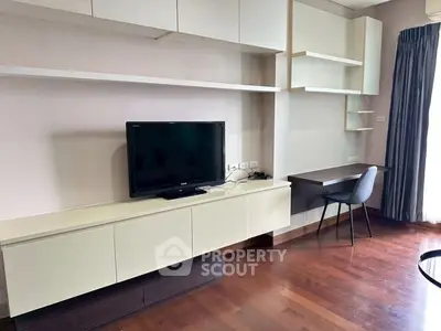 Modern living room with built-in TV unit and study desk, featuring elegant wooden flooring.