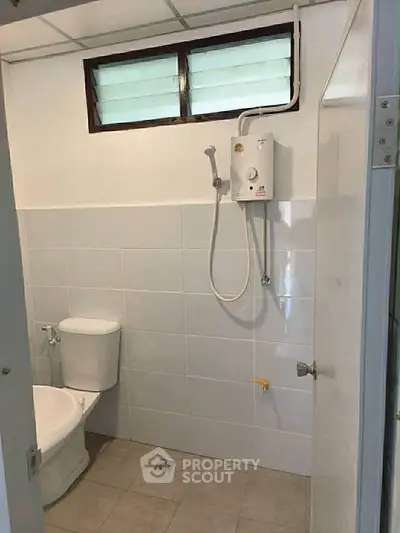 Compact bathroom with shower and toilet, ideal for small spaces.