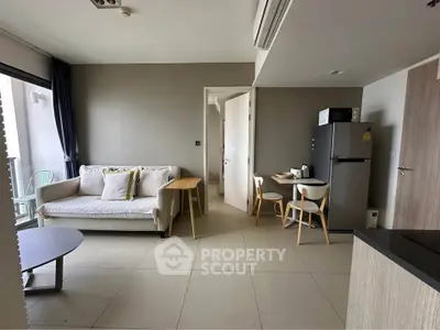 Modern living room with cozy sofa and dining area in open layout apartment.