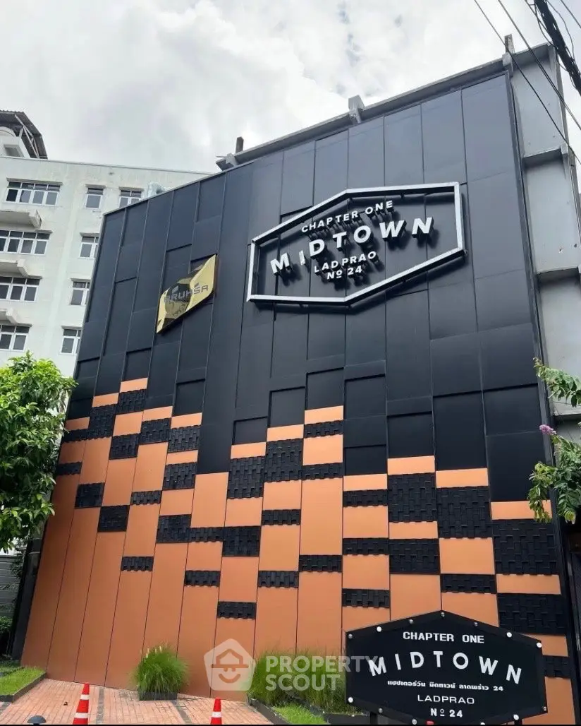 Modern building facade with unique geometric design and prominent signage at Chapter One Midtown Ladprao.