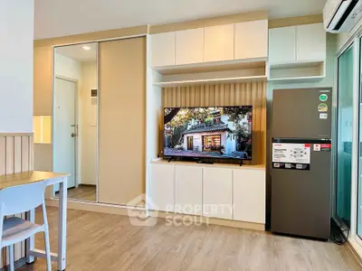Modern living room with sleek storage, TV, and stylish decor in a contemporary apartment.