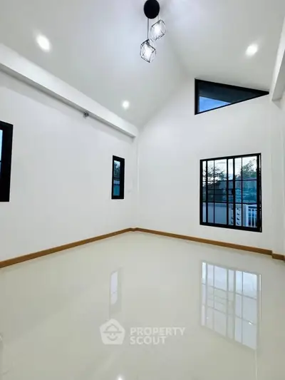 Spacious modern living room with high ceilings and large windows, perfect for natural light.
