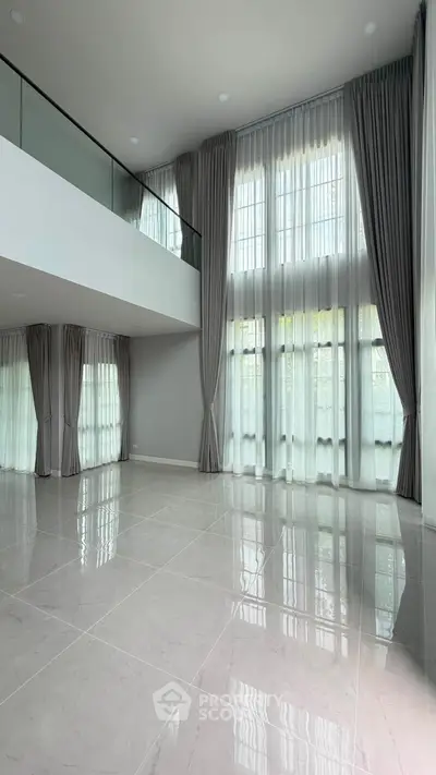Spacious modern living room with high ceilings and large windows, perfect for natural light.