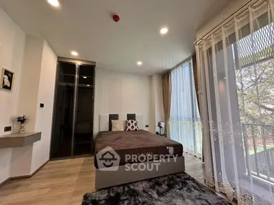Spacious bedroom with large windows and modern decor in a stylish apartment.