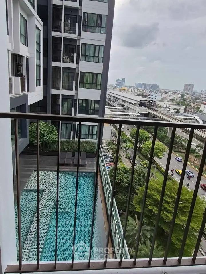 Modern high-rise building with pool view from balcony, showcasing urban living.